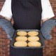 Person wearing Flame Retardant 17'' Charcoal Oven Mitts holding a tray of cookies